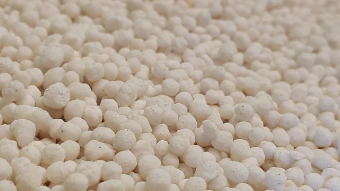 Close-up image of ammonium nitrate granules, commonly used as a synthetic fertilizer to provide essential nutrients to plants.