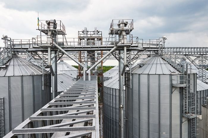 Modern industrial grain storage facilities for corn, representing the scale and technological advancement in corn farming during the industrial revolution.