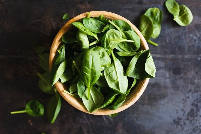 A bowl of fresh basil leaves, illustrating the herb's culinary uses for enhancing the flavor and aroma of various dishes.