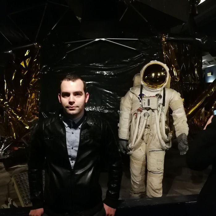 Kristian Angelov, founder of GardenInsider.org, standing next to a space suit exhibit, showcasing his interest in technology alongside his expertise in gardening and economics