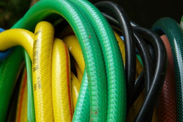A close-up of various colorful garden hoses, illustrating the different options available when choosing the right garden hose for your gardening needs.