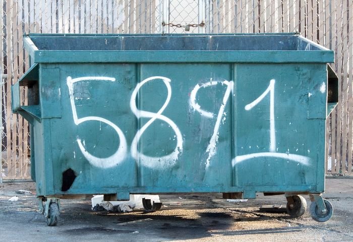 A large stationary compost bin marked with the number "5891," illustrating the benefits and limitations of using stationary bins for composting large amounts of garden waste.