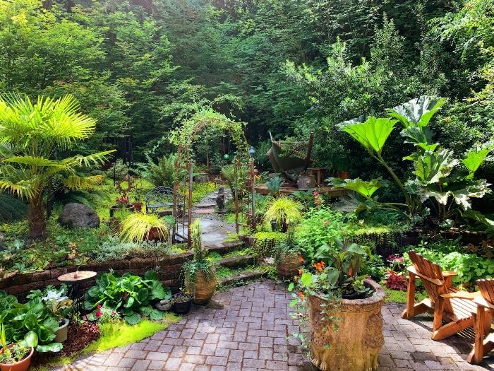 A beautifully landscaped garden featuring retaining walls, pathways, and various plants, showcasing effective hardscaping solutions to combat erosion and manage water flow.