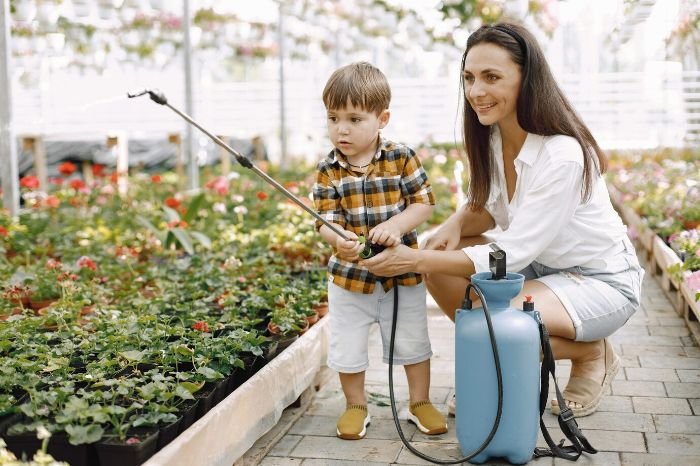 Mother and child enjoying gardening together in a kid-friendly garden, emphasizing fun and safe plants for children's gardens.