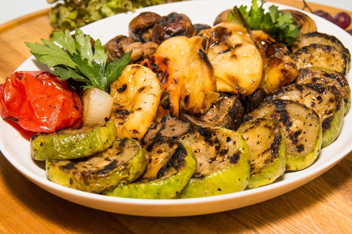 A plate of grilled zucchini slices along with other roasted vegetables, showcasing a healthy, low-carb option perfect for incorporating zucchini into your diet, especially for keto or low-carb meal plans.