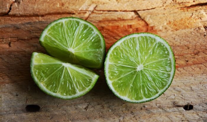 Freshly cut lime slices on a wooden surface, highlighting the antioxidant properties and health benefits of Vitamin C.