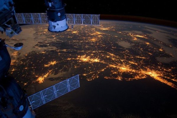Satellite capturing night-time view of Earth, representing the use of satellite data for crop forecasting and area assessment in agriculture.