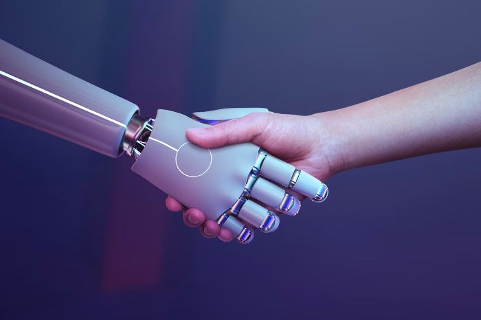 Human shaking hands with a robot, symbolizing the introduction of AI technology in agriculture