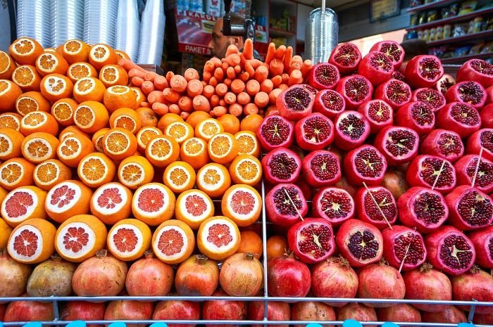 Display of fresh citrus fruits and pomegranates, highlighting the benefits and cultivation tips for Vitamin C-rich citrus fruits.
