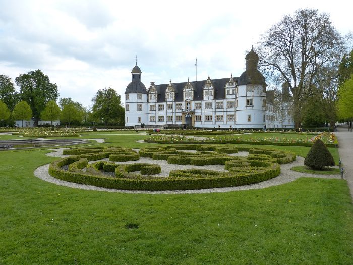 Beautiful formal garden with boxwood hedges, showcasing the enhanced aesthetics achieved through companion planting for added contrast and vibrancy.