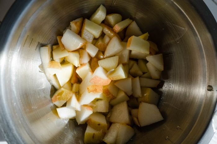 Chopped homegrown pears in a bowl, highlighting the process of harvesting, storing, and preparing pears for use in recipes.