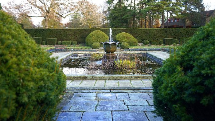 Garden water feature with fountain and pond, showcasing troubleshooting tips for common issues in water feature maintenance.