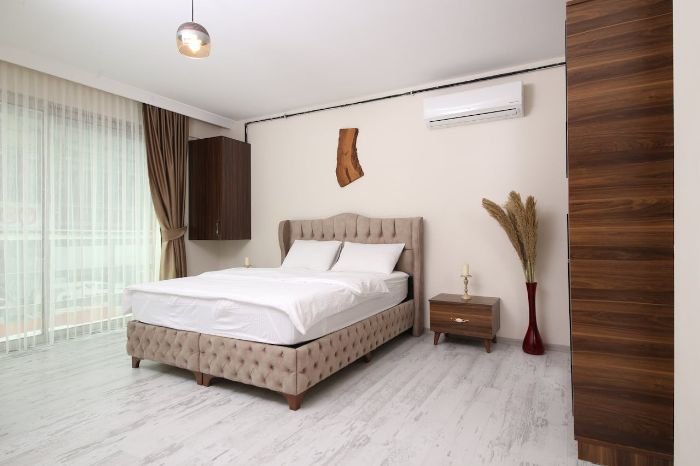 Modern bedroom with air conditioning and cozy setup, illustrating how to adjust for personal sleep preferences and comfort needs.