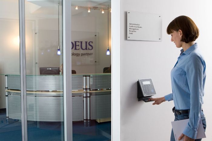 Woman using a smart access panel in an office setting, illustrating final tips for choosing the right smart lock