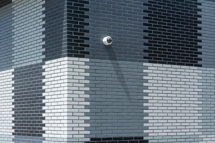 Wall-mounted security camera on a modern building, illustrating common concerns and troubleshooting for Wi-Fi cameras