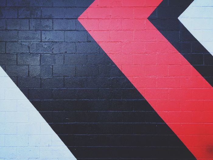 Bold geometric wall design featuring red, black, and white patterns, showcasing creative painting techniques for beginners.