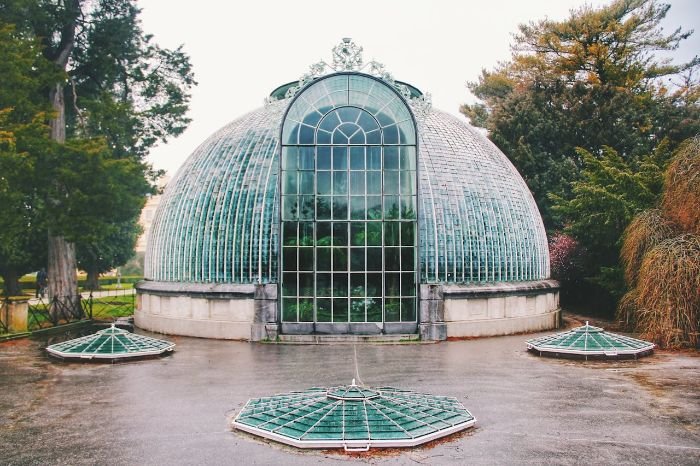 Elegant Victorian-style freestanding greenhouse with glass panels, illustrating the flexibility and range of sizes available for greenhouse structures that can be placed in optimal sunlight locations for better plant growth.