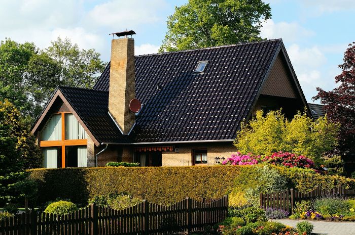 Beautiful home surrounded by lush hedges and greenery, illustrating the role of hedges in reducing wind speed and enhancing property aesthetics.
