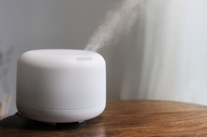 Smart humidifier releasing mist on a wooden table, showcasing effective humidity control for balanced indoor air quality and improved home health.