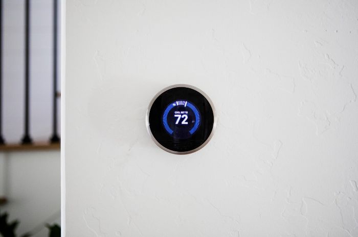 A wall-mounted smart thermostat set to 72 degrees, illustrating the integration of smart thermostats with other smart home systems for seamless temperature control and enhanced home efficiency.