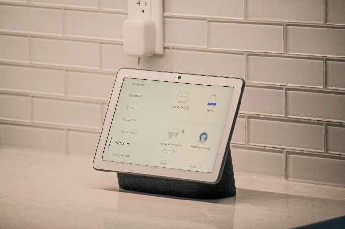 Smart home display on a countertop showing a connected thermostat and other controls, representing learning and adaptive technology in devices like smart thermostats that improve energy efficiency.