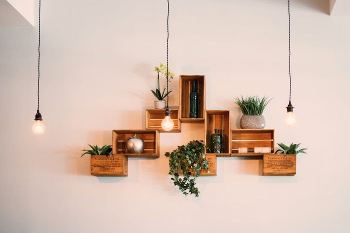 Creative wooden crate shelves mounted on a wall with plants and decor items, illustrating material choices like plywood, lumber, and glass for durable and stylish shelving solutions.