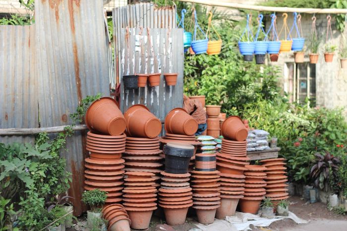 Stacked terracotta pots and colorful hanging planters, showcasing options for selecting the right containers to complement garden design and enhance outdoor aesthetics.