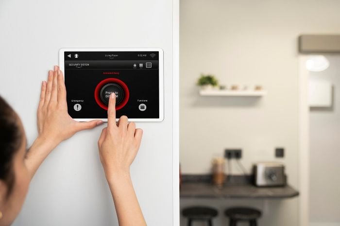 A person adjusting a smart thermostat with air quality monitoring features, highlighting advanced HVAC control for improved indoor comfort and health.