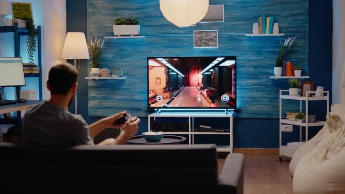 Person using a smart TV with a gaming interface, emphasizing the importance of adjusting privacy and security settings to protect personal data.