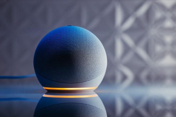 Modern voice-activated speaker with glowing LED base, highlighting its role in transforming home audio experiences with hands-free control and smart technology.