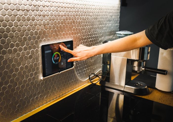Person adjusting a smart humidity control system on a sleek touchscreen panel in a modern kitchen, maintaining ideal indoor humidity levels.