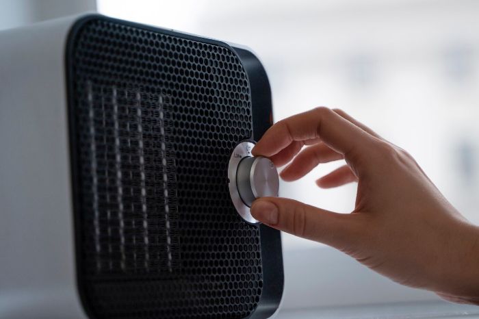 Hand adjusting the settings of a smart air purifier, emphasizing the importance of regular maintenance, including cleaning and replacing filters, to ensure optimal performance and clean air quality.