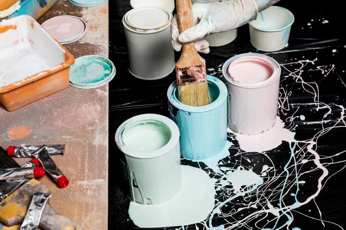 Painting supplies with colorful paint cans and brushes, representing creative accent wall ideas to transform a room's design and atmosphere.
