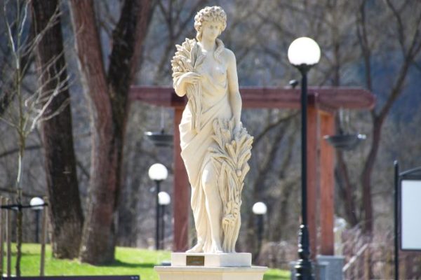 Elegant classical statue in a landscaped garden, illustrating how sculptures can enhance garden design aesthetics and add focal interest.