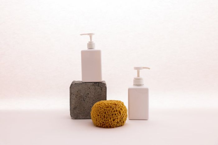 Eco-friendly cleaning tools including wooden brushes, cellulose sponges, and loofahs arranged on a neutral background, highlighting biodegradable and zero waste alternatives.