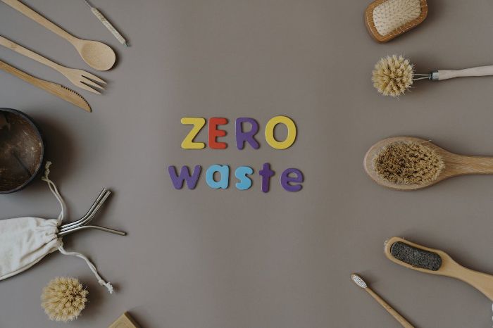 Flat lay of reusable and biodegradable cleaning tools with colorful "Zero Waste" text, representing eco-friendly cleaning practices and sustainable product choices.